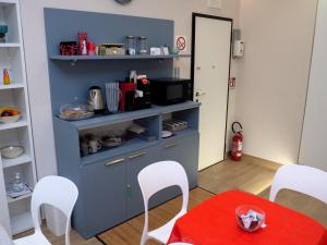 a kitchen with a blue cabinet and white chairs at L'Oasi del Poeta in Crotone