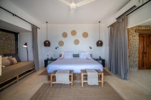 a bedroom with a large white bed and a couch at Inkaterra Cabo Blanco in Talara