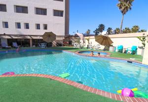 a pool at a hotel with people in it at Hotel Corona Plaza in Rosarito