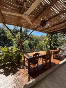 a wooden table and chairs under a wooden pergola at Green oasis across from the main street in Mazunte +8 photos