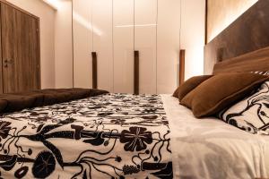 a bedroom with a bed with a black and white blanket at Al Melograno in Aquilinia