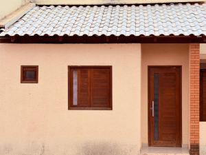a house with two windows and a door at Flat Studio Casal - Praia da Lagoa do P a u - Coruripe in Coruripe
