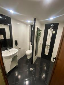 a bathroom with a white sink and a toilet at Къща за гости Гергана in Ribarica