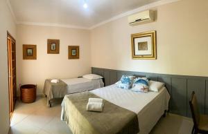 a bedroom with two beds and a table in it at Pousada Praeros in Rifaina