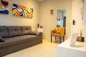 a living room with a couch and a chair at Book Santos Mar à Vista no Unique Residence 1810 in Santos