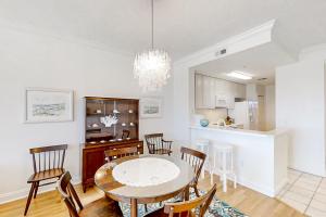 a kitchen and dining room with a table and chairs at Beautiful Oceanfront Getaway w/Shared Pool, Central AC, Elevator, & W/D in Fernandina Beach