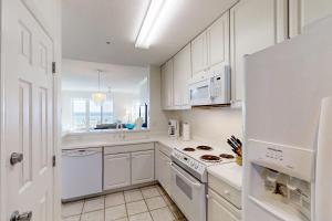 a kitchen with white cabinets and a white stove top oven at Beautiful Oceanfront Getaway w/Shared Pool, Central AC, Elevator, & W/D in Fernandina Beach +24 photos
