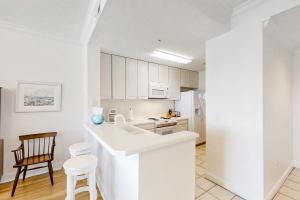 a kitchen with white cabinets and a white counter top at Beautiful Oceanfront Getaway w/Shared Pool, Central AC, Elevator, & W/D in Fernandina Beach