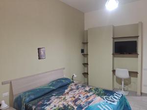 a bedroom with a bed and a flat screen tv at B&B I Gigli in Brusciano