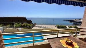 a balcony with a view of a swimming pool and the ocean at Serigor Bahía Ocean View in Puerto de Santiago +35 photos