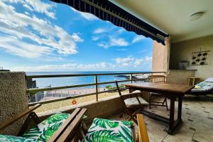 a balcony with a table and chairs and the ocean at Serigor Bahía Ocean View in Puerto de Santiago