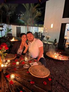 a man and woman sitting at a wooden table at Cerro Tusa Glamping in Titiribí