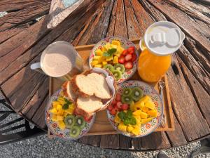 a tray of food with sandwiches and fruit and a drink at Cerro Tusa Glamping in Titiribí
