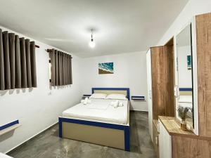 a bedroom with a bed and a mirror at Vila Laura in Ksamil
