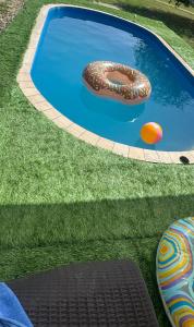 a swimming pool with two inflatables in the grass at Èlmèny Vendègház in Csurgó