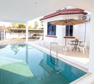 a house with a swimming pool and an umbrella at Private pool Villa3rooms in Siem Reap