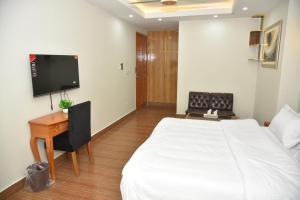 a bedroom with a bed and a desk and a tv at Modern Hotel with Free Wi-Fi Parking,210 in Muzaffarabad