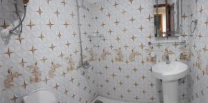 a bathroom with a white toilet and a sink at Modern Hotel with Free Wi-Fi Parking,210 in Muzaffarabad +7 photos