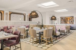 ein Restaurant mit Tischen und Stühlen in einem Raum in der Unterkunft The Don CeSar in St Pete Beach