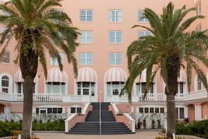 ein rosafarbenes Gebäude mit Palmen davor in der Unterkunft The Don CeSar in St Pete Beach