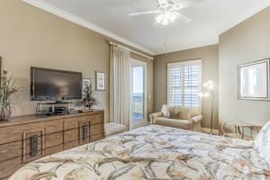 a bedroom with a large bed and a flat screen tv at Oceanfront 5th-floor condo with balcony, gorgeous views & pool access in Fernandina Beach +24 photos
