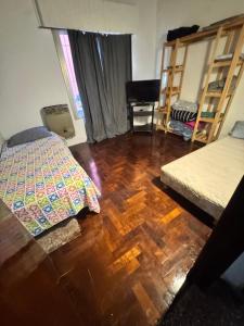 a bedroom with two beds and a wooden floor at casa en escobar con cocheras in Belén de Escobar +13 photos