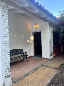 a bench sitting on the side of a white building at casa en escobar con cocheras in Belén de Escobar