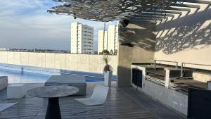 a rooftop patio with a table and a pool at Modern apartment in Angelopolis - 2 bedrooms in Tlazcalancingo