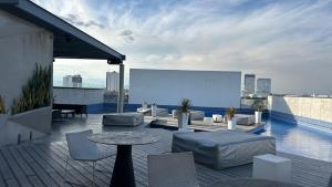 a rooftop patio with a table and chairs on a building at Modern apartment in Angelopolis - 2 bedrooms in Tlazcalancingo