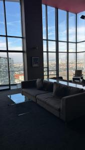 a living room with a couch and large windows at Modern apartment in Angelopolis - 2 bedrooms in Tlazcalancingo