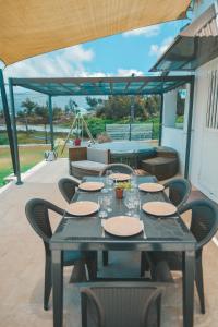 a table with plates and glasses on a patio at L'Escapade des Hauts location saisonnière avec jacuzzi in Le Tampon