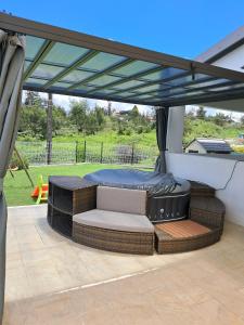 a gazebo with a bed and a patio at L'Escapade des Hauts location saisonnière avec jacuzzi in Le Tampon