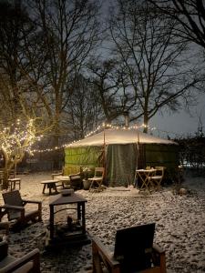 a yurt with lights in the snow at night at Het binnenerf yurt en keetjes in Nieuwleusen