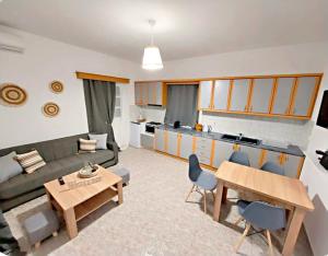 a living room with a couch and a table and a kitchen at Elli's House in Perivolos
