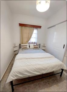 a bedroom with a large bed with a window at Elli's House in Perivolos