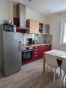 a kitchen with red cabinets and a stainless steel refrigerator at Harznester Schierke in Schierke