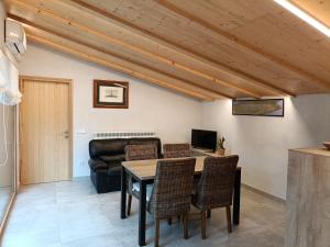 a living room with a table and chairs and a couch at El Freixe de l'Ylla in Els Hostalets