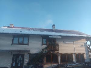 a white house with a fire ladder on it at У Матвія in Vorokhta