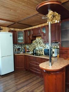 a kitchen with wooden cabinets and a white refrigerator at У Матвія in Vorokhta +23 photos