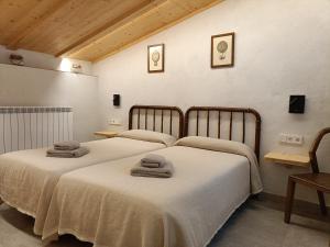 two beds in a room with towels on them at El Freixe de l'Ylla in Els Hostalets