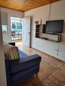 a living room with a couch and a flat screen tv at Mariposa 88 in Puerto Rico