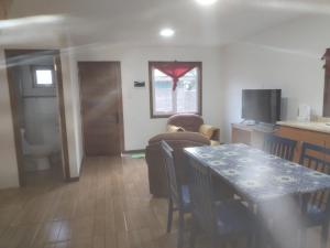 a living room with a dining table and a kitchen at Cabañas Drü 3 in Coihaique