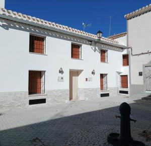 a white building with windows on the side of it at La Ermita Casa Rural in Benablón