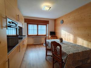 a dining room with a table and a kitchen at Appartamento panoramico 1 in Dosoledo