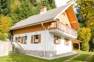 une maison avec des éléments en bois et une cour dans l'établissement Cottage House Jakob, à Cerklje na Gorenjskem