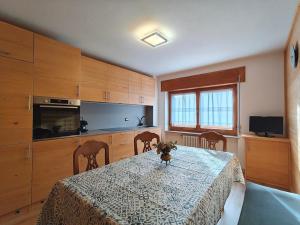 a kitchen with a table and some chairs and a kitchen with a tableablish at Appartamento panoramico 1 in Dosoledo +5 photos