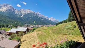 a view of a village on a hill with mountains at Appartamento panoramico 1 in Dosoledo