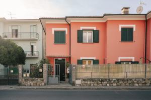 an orange house with green shutters on a street at tra il borgo e il mare in Cervo