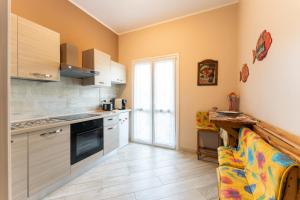 a kitchen with white cabinets and a stove top oven at tra il borgo e il mare in Cervo