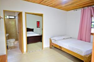 a bedroom with two beds and a bathroom at El Ranchito de Turbo in Turbo +3 photos